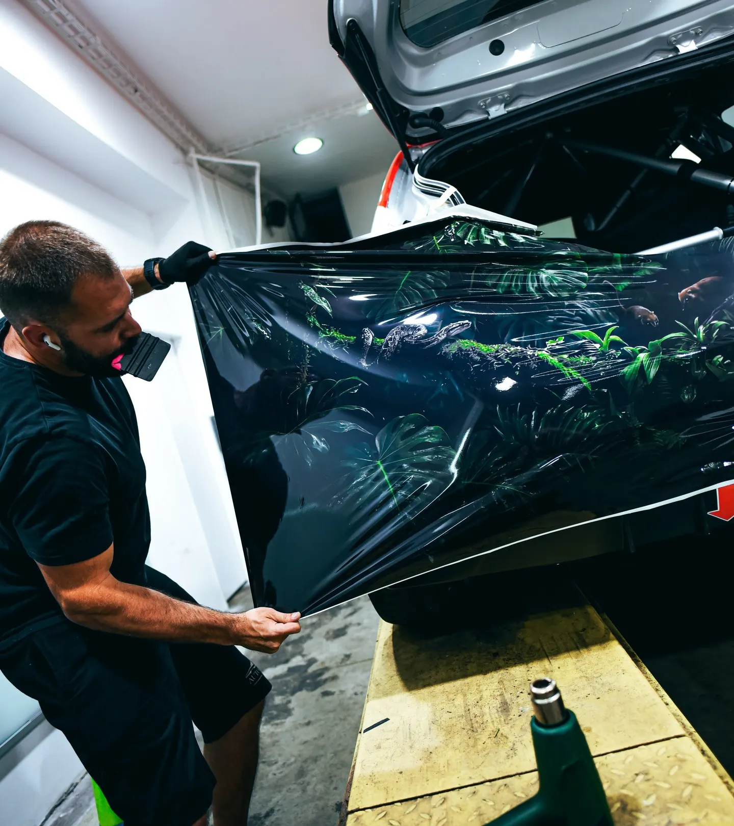 Technik napíná velkoformátovou potištěnou fólii před aplikací na karoserii