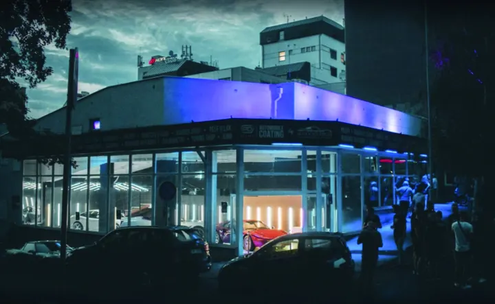 Budova Autocentra Pařížská večer, s modře nasvícenou fasádou